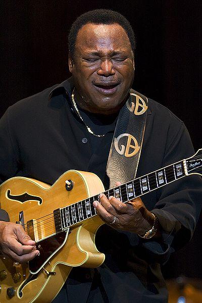 George Benson playing guitar on stage