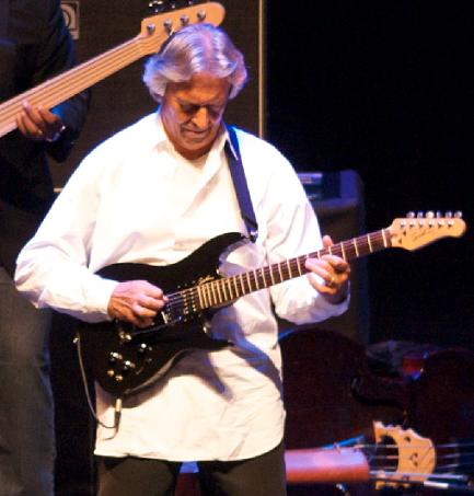 John McLaughlin playing guitar on stage