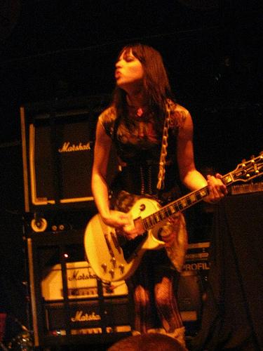Lzzy playing guitar on stage with Halestorm
