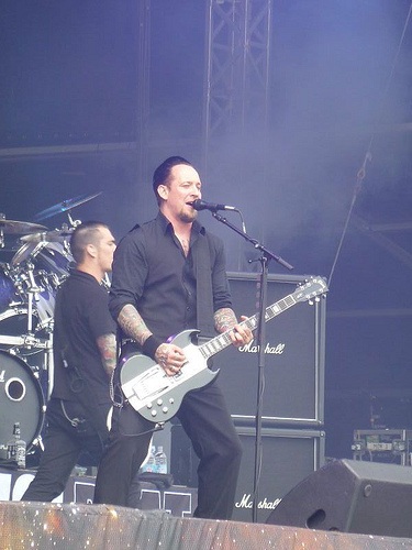 Michael Poulsen playing guitar with Volbeat