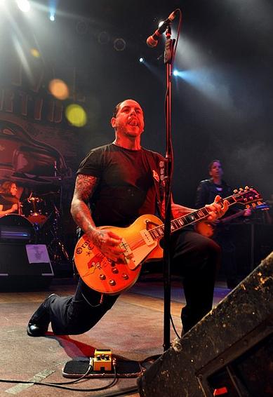 Mike Ness playing guitar live on stage