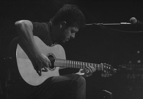 Rodrigo playing acoustic guitar on stage