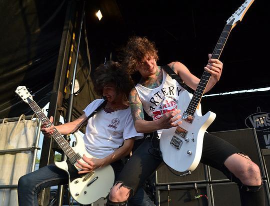 Cameron Liddell playing guitar on stage