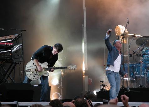 Charlie playing guitar with Simple Minds