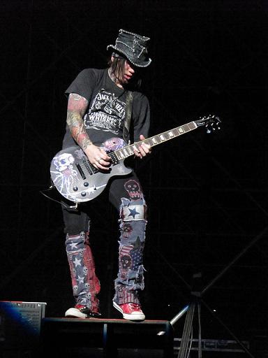 DJ Ashba playing guitar on stage