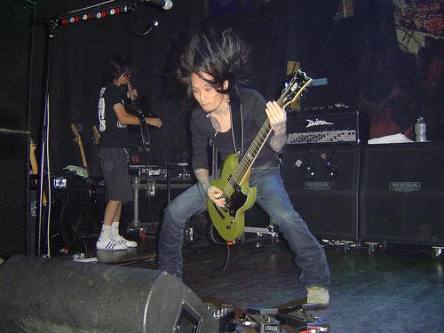 Kaoru playing guitar on stage