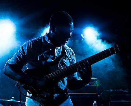 Tosin Abasi playing guitar at concert