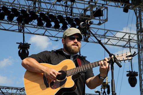 Zac playing acoustic guitar on stage